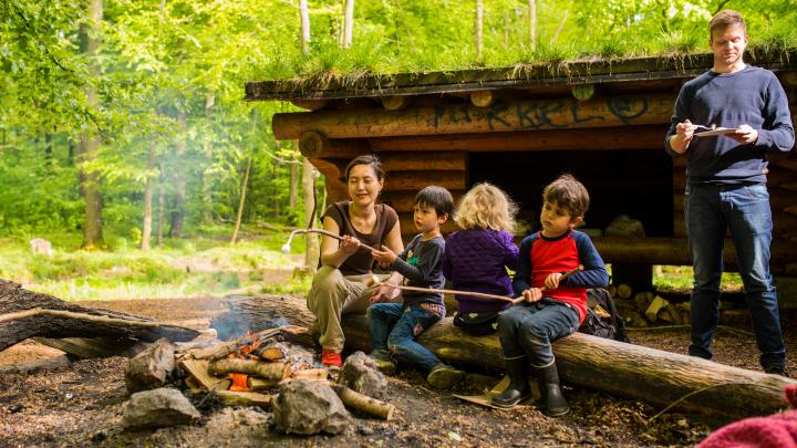 Familiespejdere ved bål foran shelter